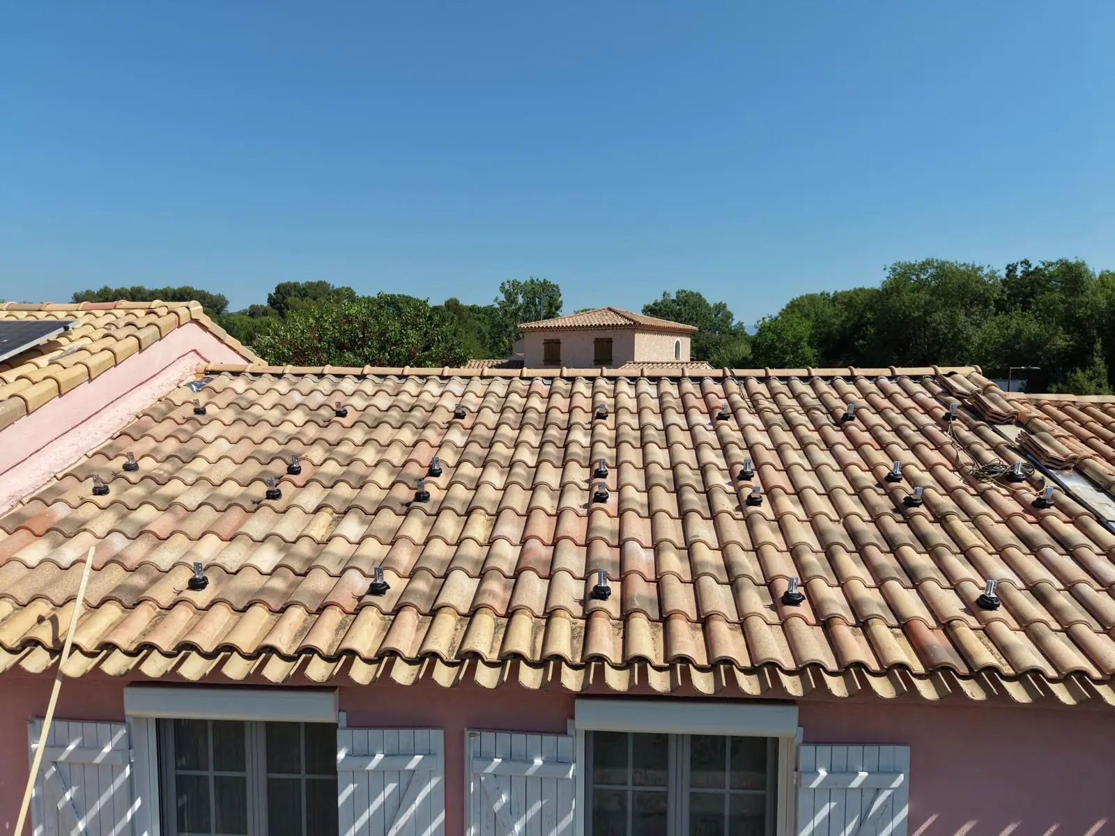 Crochets de fixation photovoltaïque posés sur une toiture en tuiles