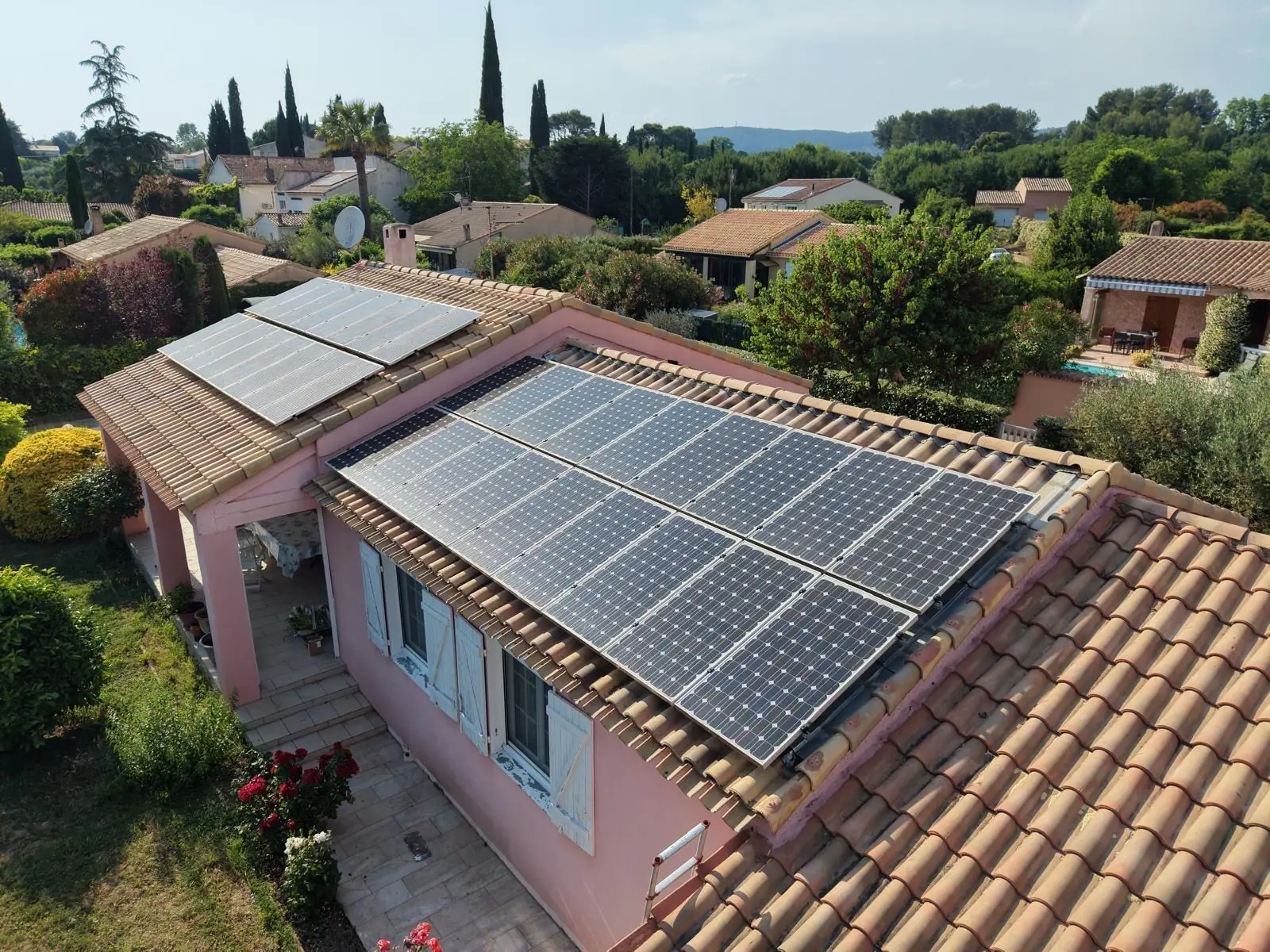 Panneaux solaires reposés en surimposition sur une toiture de maison, vue de drone