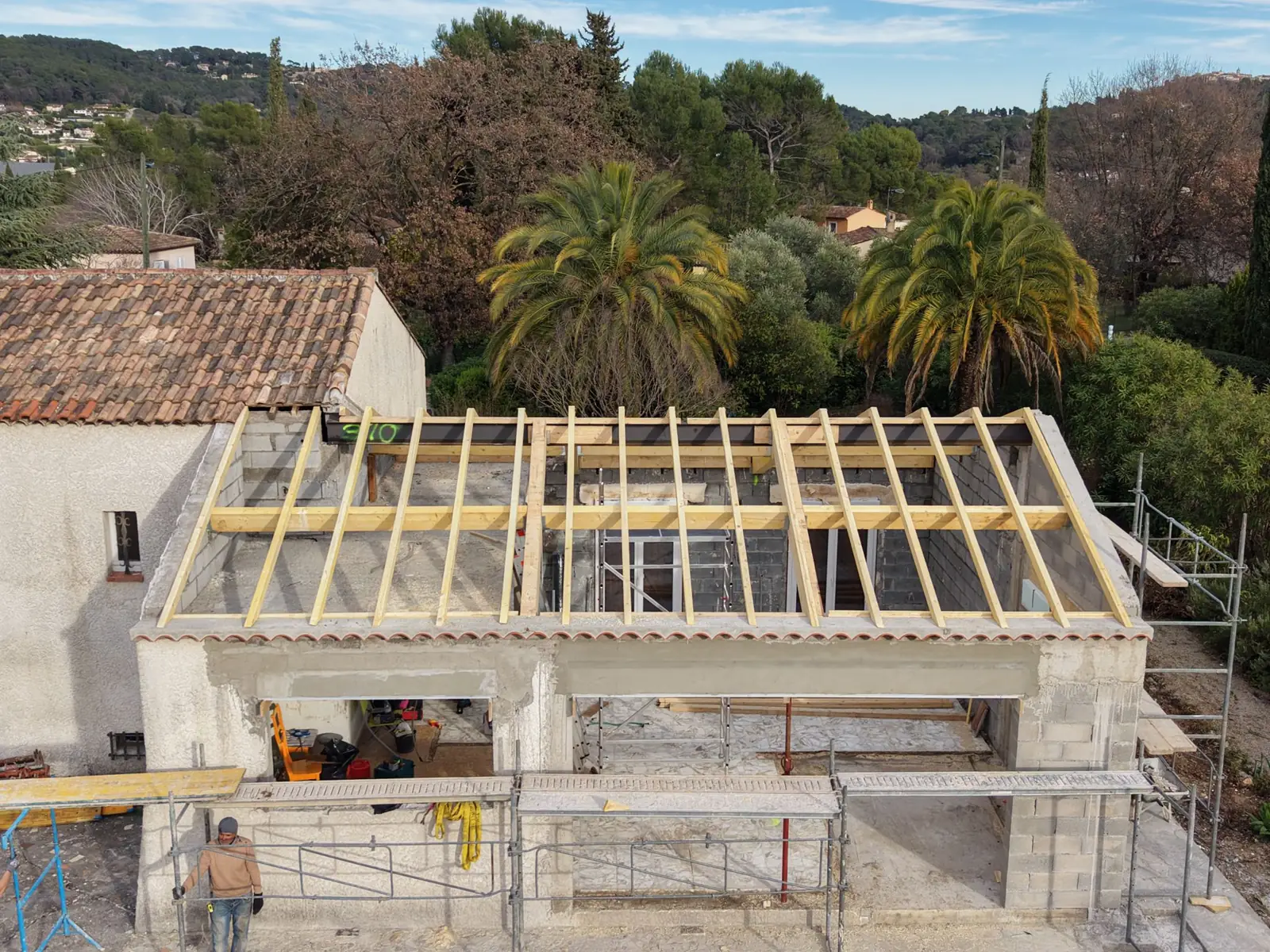Pose d'une charpente bois sur une maison sous échafaudage